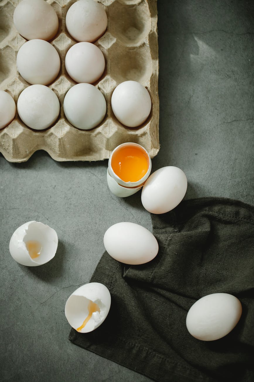 raw cracked eggs placed in box on table